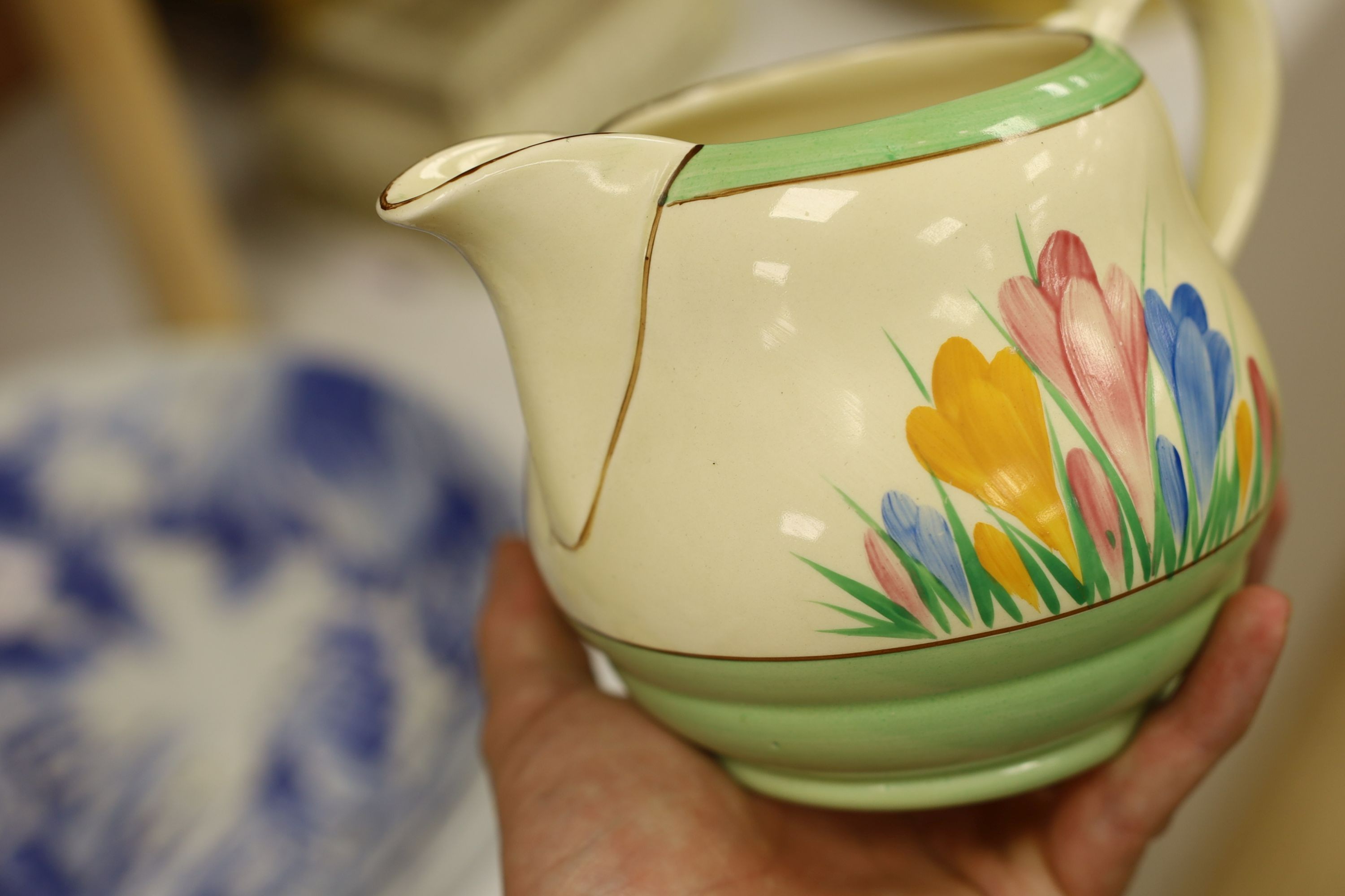 A Clarice Cliff crocus design milk jug and a Bizarre patterned side plate, jug 11.5 cms high
